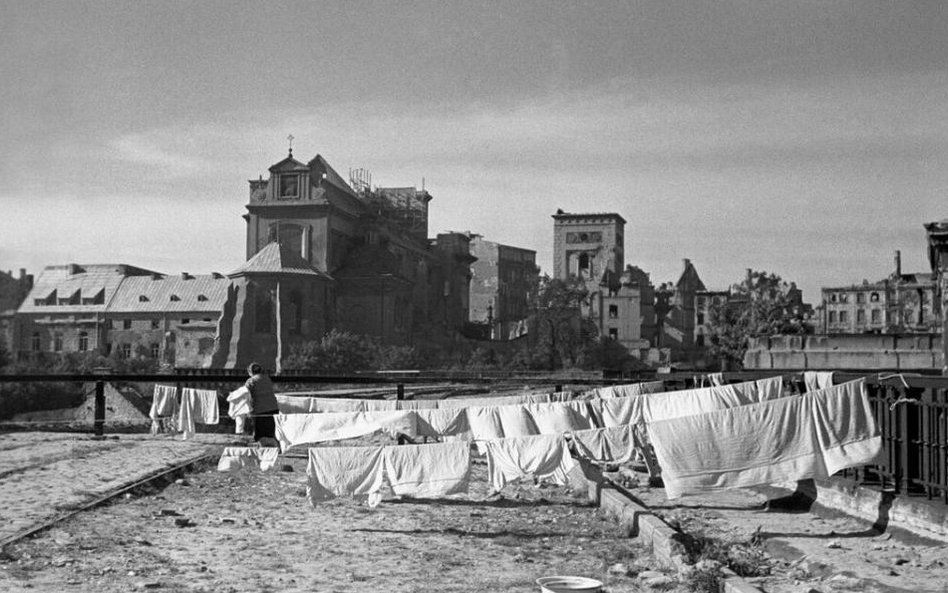 Warszawa 1946, fot. Jerzy Baranowski. Kobieta wywiesza pranie na sznurach rozci ą gni ę tych pomi ę 