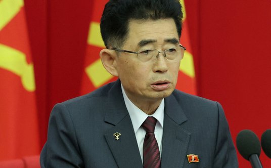 Przedstawiciel Korei Północnej ze znaczkiem z wizerunkiem Kim Dzong Una