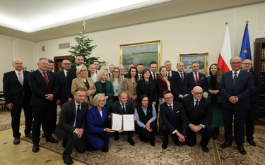 Premier Donald Tusk pozuje do pamiątkowego zdjęcia, po tym jak odebrał uchwałę Sejmu RP w sprawie wy
