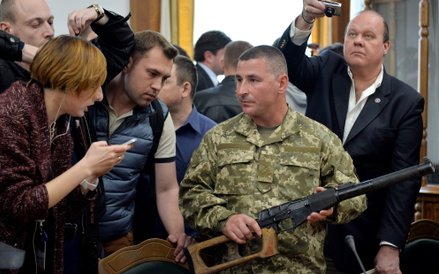 Ukraiński oficer pokazuje na konferencji prasowej broń jednego ze złapanych Rosjan: 9-milimetrowy ka