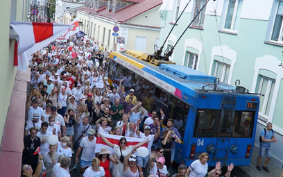 Radosny protest z flagami biało-czerwono-białymi w centrum Grodna