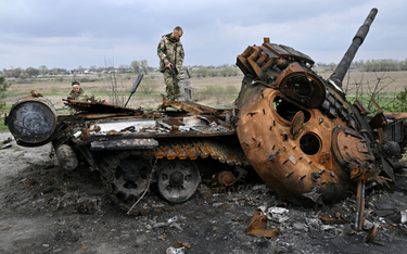 Ukraiński żołnierz przy zniszczonym rosyjskim czołgu, obwód kijowski, fotografia z 16 kwietnia
