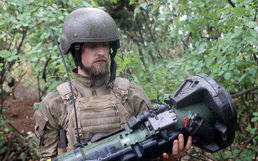 Ukraiński żołnierz trzyma w rękach szwedzko-brytyjską ręczną wyrzutnię przeciwpancerną NLAW