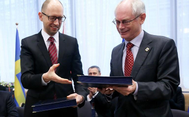 Premier Ukrainy Arsenij Jaceniuk i przewodniczący Rady Europejskiej Herman Van Rompuy wymieniają się
