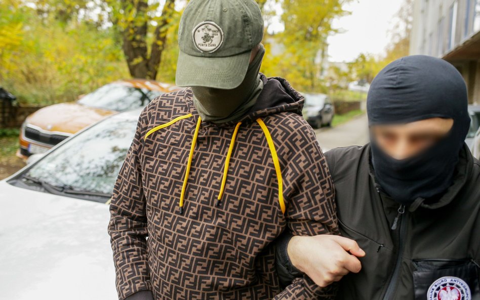 Zatrzymany twórca marki Red is Bad Paweł S. (L) podczas doprowadzenia do siedziby Śląskiego Wydziału
