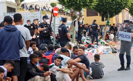 Migranci w Ceucie zgromadzeni wokół tymczasowego schroniska