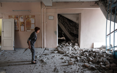 Nauczycielka w uszkodzonym w wyniku ostrzału budynku szkoły w mieście Bachmut (obwód doniecki), foto