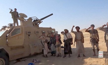 Powiązani z Iranem bojownicy Huti pozują przy zdobytym pojeździe po ataku na siły wspierane przez Ar