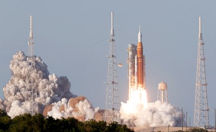 Rakieta Space Launch System o wysokości 98 metrów, wynosząca kapsułę załogową Orion z astronautami m