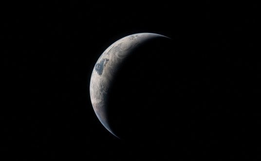 Widok Ziemi widziany przez członka załogi statku Artemis II przez okno statku kosmicznego Orion