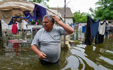 Mężczyzna na zalanym podwórku swojego domu w Afanasijewce, obwód mikołajowski, 10 czerwca 2023 r., p