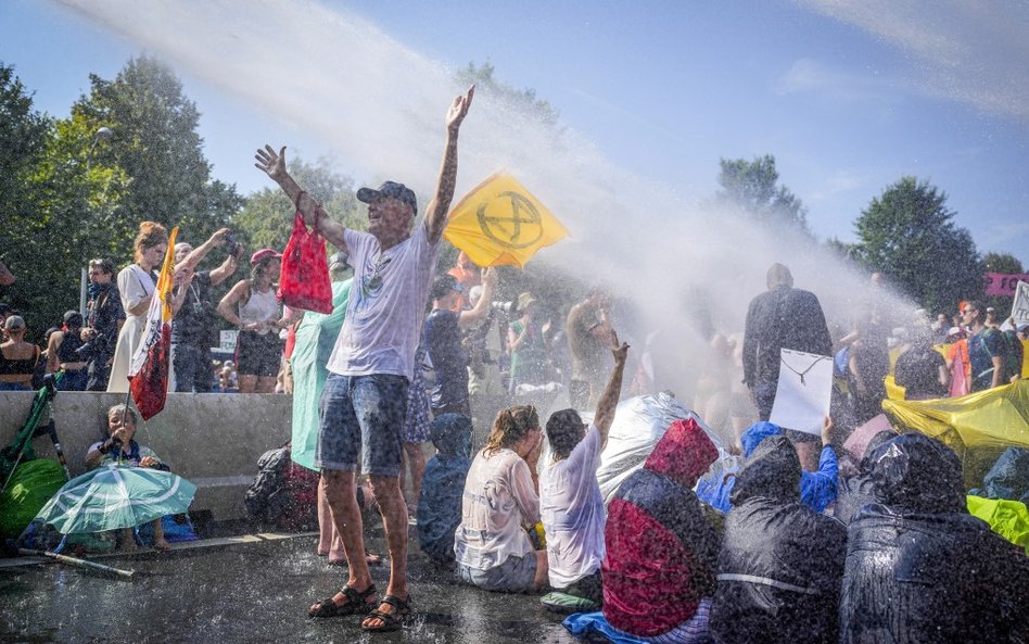 olicja używa armatek wodnych przeciwko aktywistom klimatycznym z ruchu Extinction Rebellion, którzy 