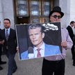 Uczestnik demonstracji zorganizowanej przed Senatem USA trzyma transparent z podobizną sekretarza ob