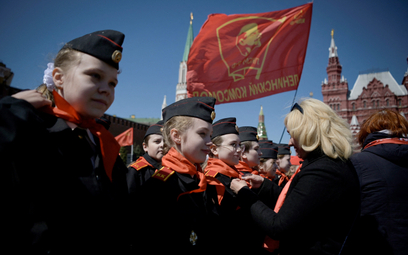 Działacze Komunistycznej Partii Rosji na placu Czerwonym zawiązują czerwone chustki na szyi młodych 
