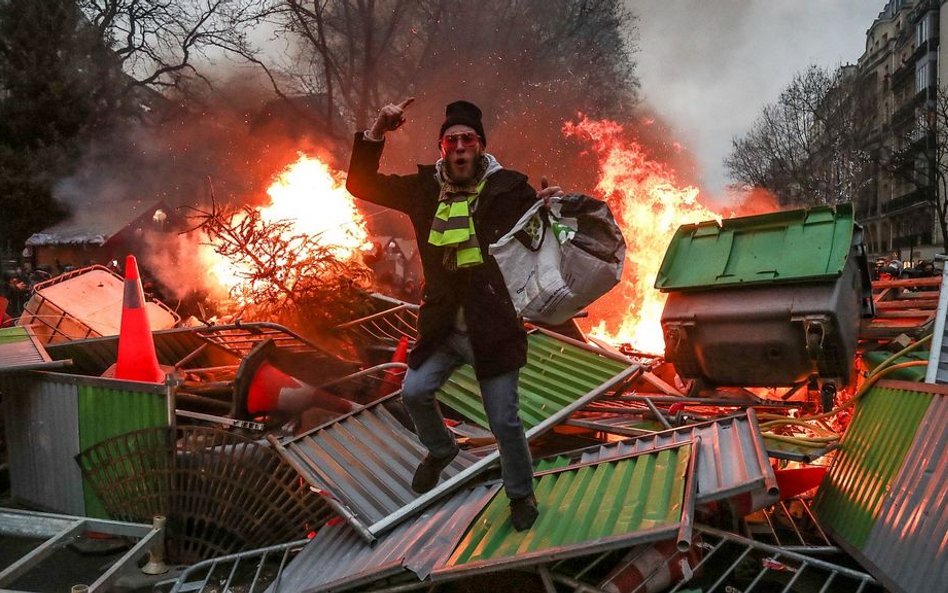 Jeden z demonstrantów na płonącej barykadzie w Paryżu, 5 stycznia