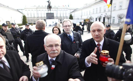 Joachim Brudziński (z prawej) wraz z innymi parlamentarzystami PiS odbiera znicze od ludzi, którzy n