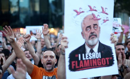 Protestujący trzyma transparent z wizerunkiem premiera Albanii Ediego Ramy podczas demonstracji prze