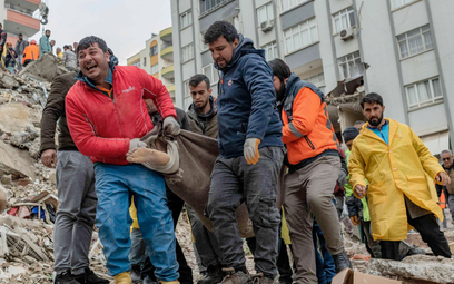 Ratownicy niosą ciało znalezione w zawalonym budynku w Adanie na południu Turcji