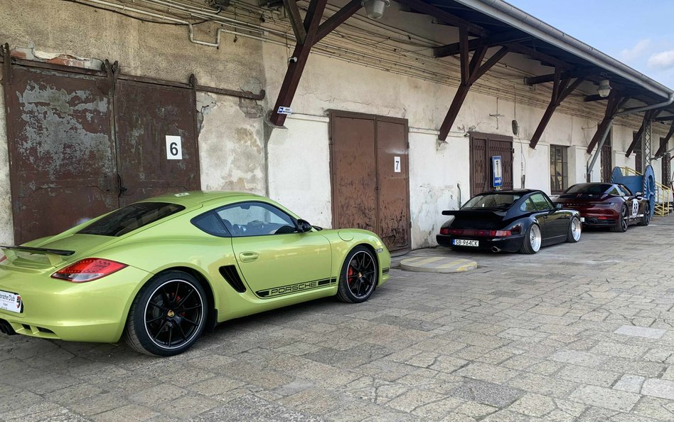 Na pierwszym planie wyróżnia się jasnozielony Cayman z czarnymi detalami, a za nim czarny 911 z duży