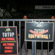 Tablice z hasłami "Zamknąć Holywings" i "Holywings bluźnierca" przed barem Holywings w Dżakarcie, fo