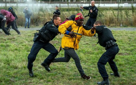 Francuscy żandarmi próbujący zatrzymać imigrantów przy Eurotunelu w Coquelles niedaleko Calais w pół