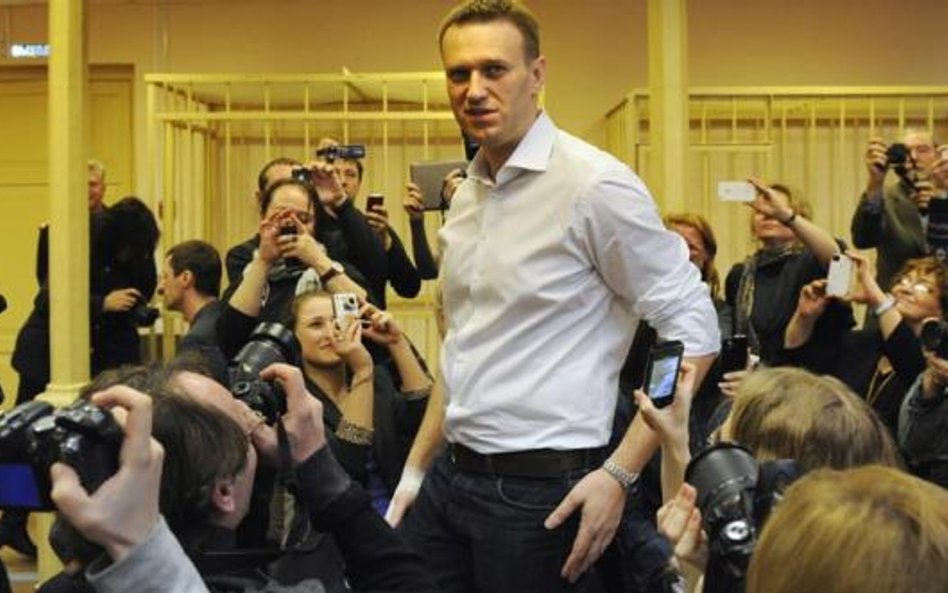 Aleksiej Nawalny oblegany przez dziennikarzy po przybyciu na salę sądową