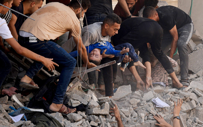 Palestyńskie dziecko wyciągane z ruin w Khan Yunis w Strefie Gazy