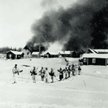 Oddział fińskich narciarzy na tle płonącej wsi