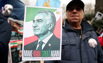 Demonstrant trzymający transparent przedstawiający Rezę Pahlawiego.