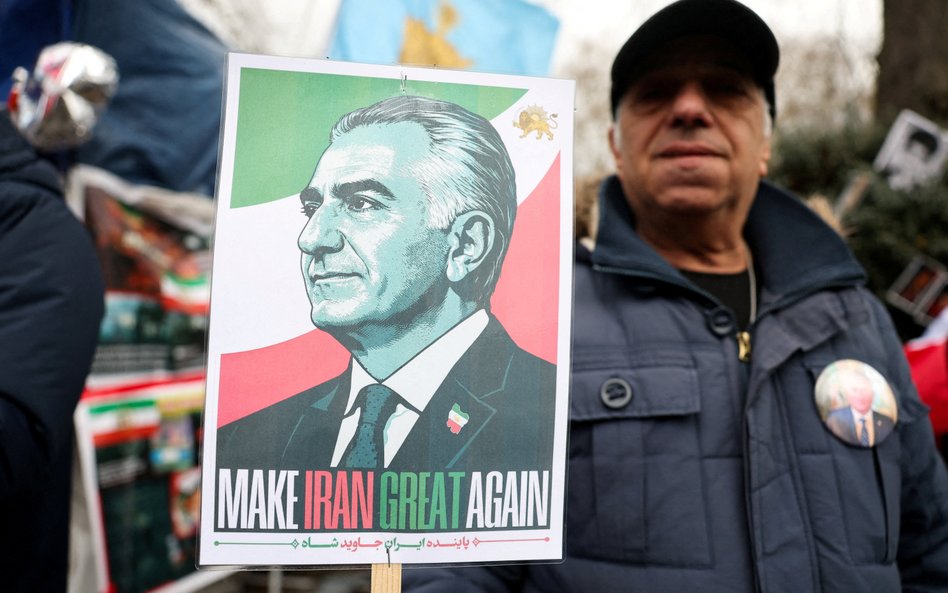 Demonstrant trzymający transparent przedstawiający Rezę Pahlawiego.