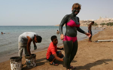 Błoto z Morza Martwego działa leczniczo na skórę. Turyści chętnie z tego korzystają.