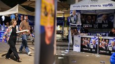 Ludzie przechodzą obok stoisk promujących partię Jaszar (po lewej) oraz partię Likud, znajdujących s