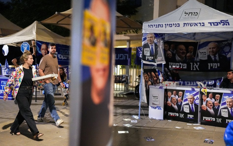 Ludzie przechodzą obok stoisk promujących partię Jaszar (po lewej) oraz partię Likud, znajdujących s