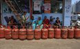 Hindusi ustawiają się w kolejkach po napełnienie pustych butli z gazem płynnym (LPG) w pobliżu biura