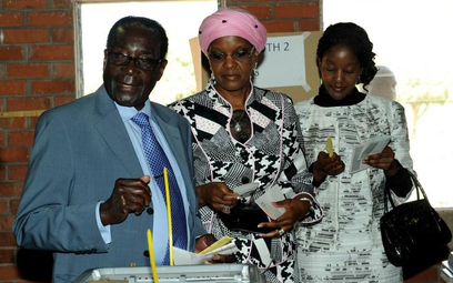 Robert Mugabe (z lewej) przy urnie wyborczej