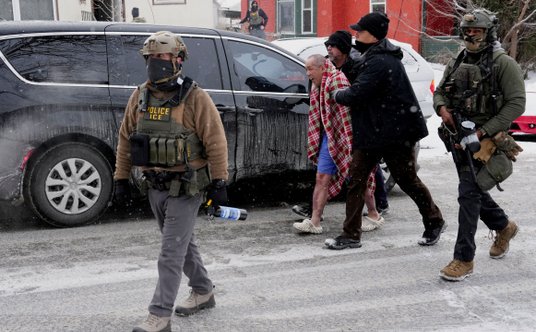 56-letni ChongLy Thao prowadzony do samochodu przez funkcjonariuszy ICE