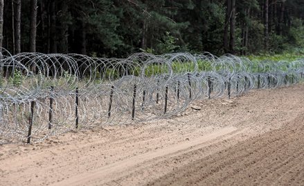 Zapora z drutu kolczastego przy pasie drogi granicznej na polsko-białoruskiej granicy w Kopczanach