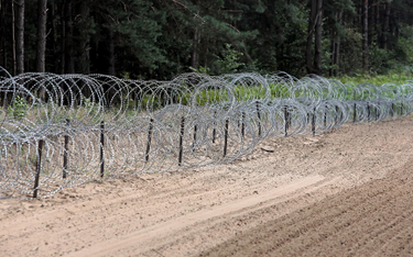 Zapora z drutu kolczastego przy pasie drogi granicznej na polsko-białoruskiej granicy w Kopczanach