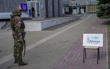 Rosyjski żołnierz z karabinem przy „punkcie głosowania” w okupowanym Mariupolu