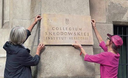 Iwona Demko (z prawej) oraz Sławomira Walczewska montują na elewacji budynku tablicę z napisami „Col