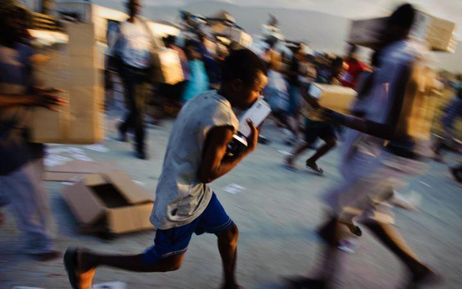 Haiti, Port-au-Prince. Poszkodowani w trzęsieniu ziemi walczą o paczki pomocy humanitarnej