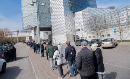 Kolejka na antycovidowe zastrzyki w budynku sztokholmskich targów przerobionym na centrum szczepień