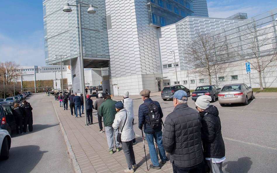 Kolejka na antycovidowe zastrzyki w budynku sztokholmskich targów przerobionym na centrum szczepień