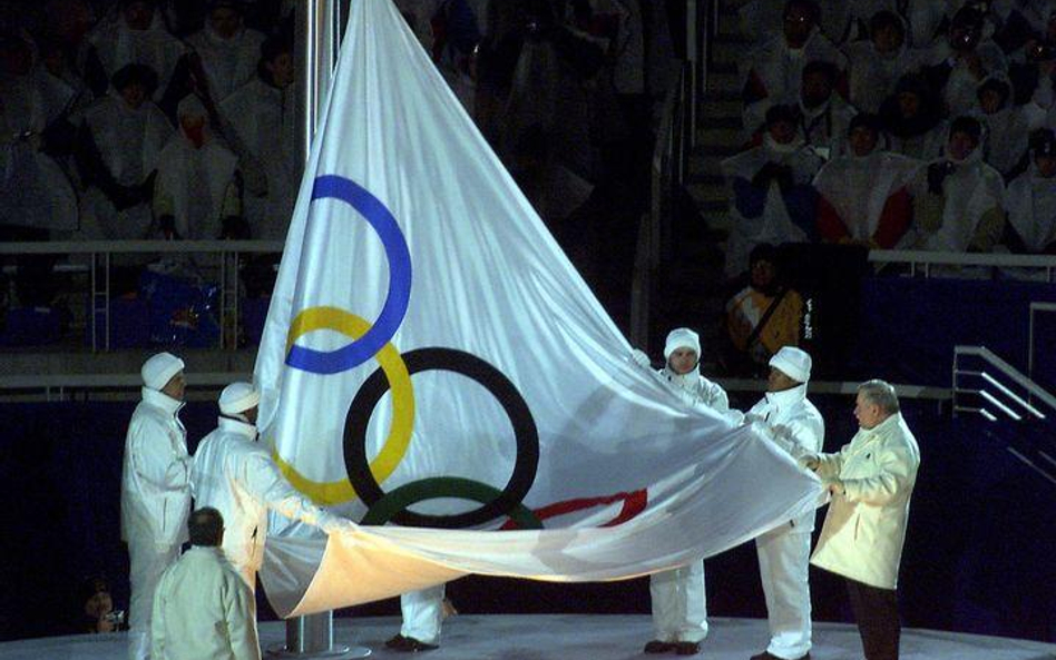 Lech Wałęsa z flagą olimpijską na stadionie Rice-Eccles Olympic w Salt Lake City