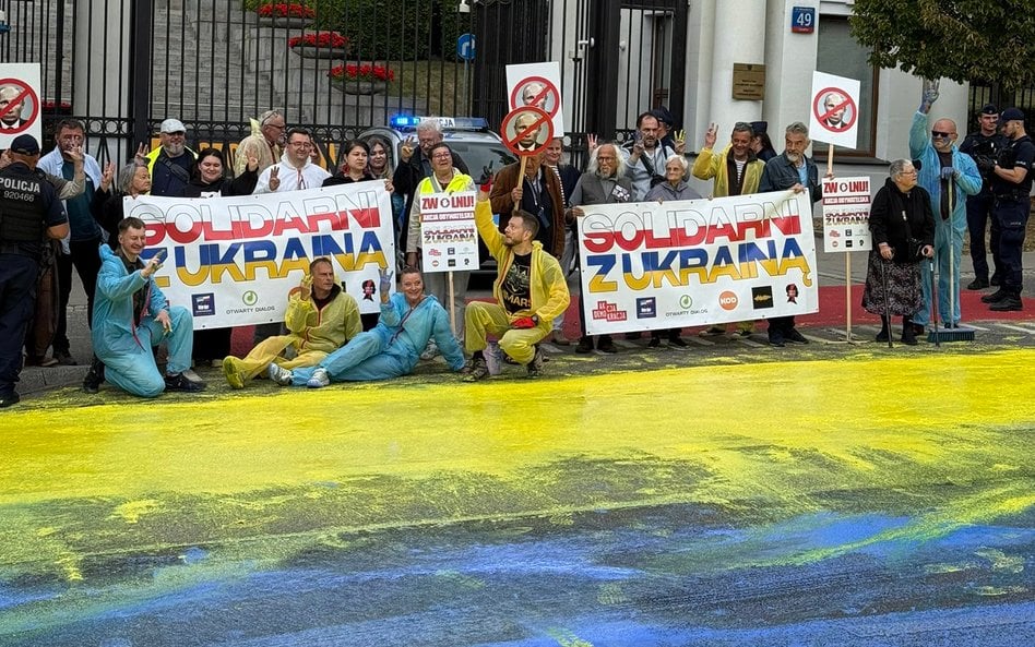 Uczestnicy akcji pozują na tle wielkiej ukraińskiej flagi namalowanej na ulicy Belwederskiej