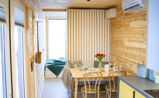 Środek kontenera zajmuje salon z kuchnią i łazienka, a oba końce sypialnie