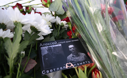 Kartka z wizerunkami zmarłego przywódcy rosyjskiej opozycji Aleksieja Nawalnego leży wśród kwiatów p
