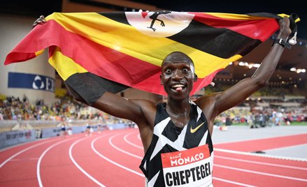 Joshua Cheptegei z flagą Ugandy po pobiciu rekordu świata w biegu na 5 km podczas mityngu Diamentowe