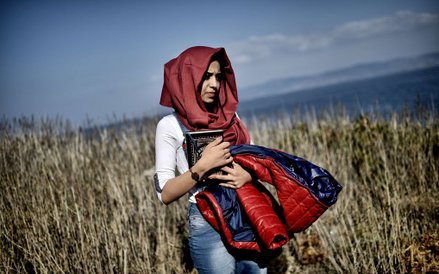 Kobieta idąca przez pole po przybyciu uchodźców i imigrantów na grecką wyspę Lesbos