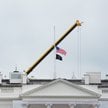 Opuszczona do połowy flaga USA nad Białym Domem.